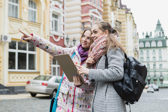 women pointing away and using tablet